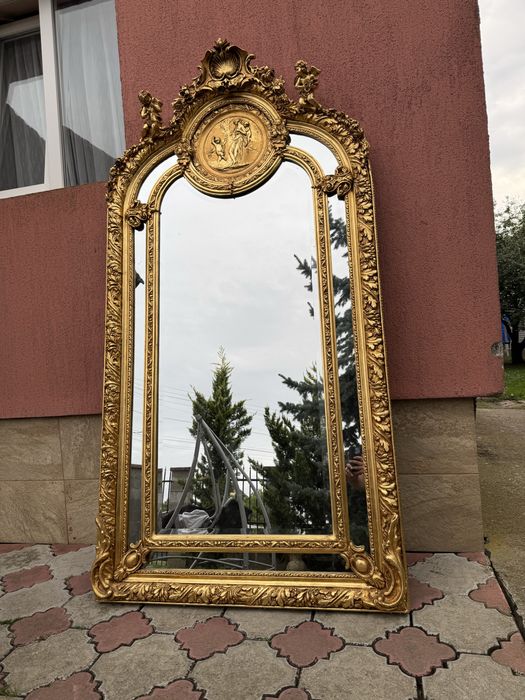 Oglinda impunatoare in stil baroc, cu rama aurie