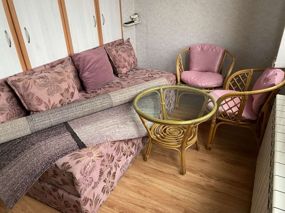 Обзавеждане за стая: диван, ратанови столове с маса и килим.