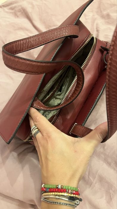 Geantă Guess bordo elegantă cu detalii aurii și textură snake