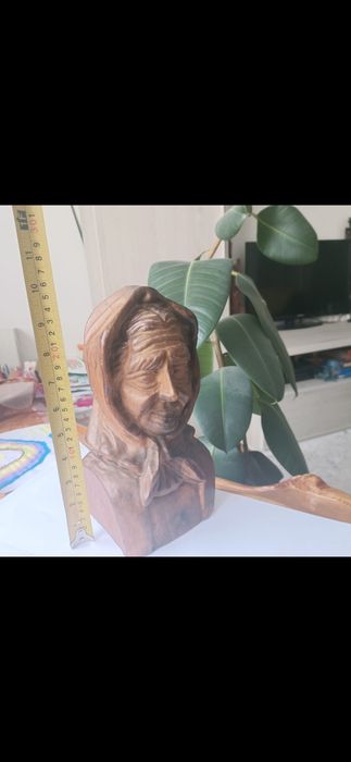 Sculptura de lemn , femeie cu batic .