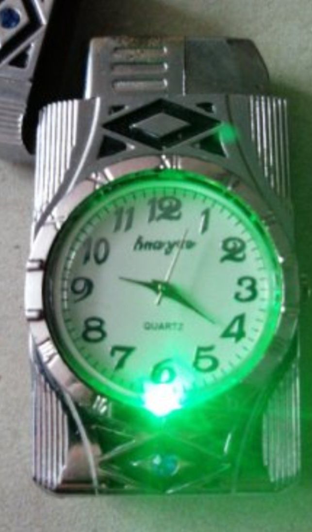 Употребявана запалка с подсветка и механичен часовник.