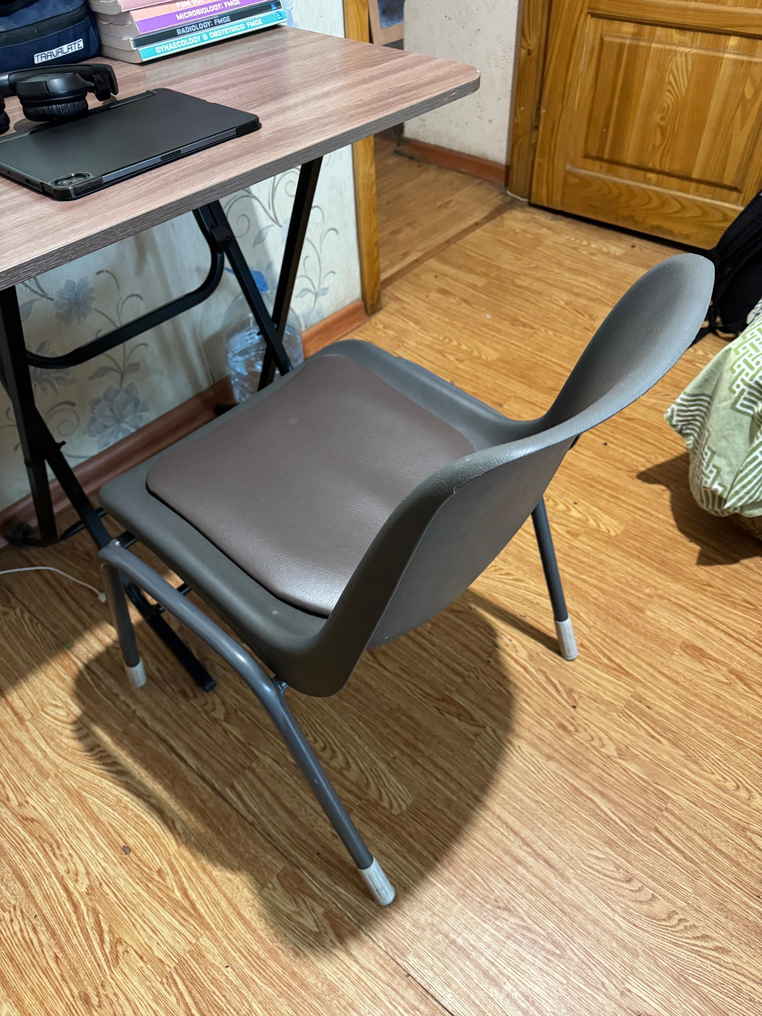 A wooden table, with comfortable chair, and a study lamp