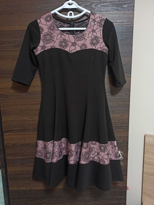 черна разкроена рокля , с розов принт на деколтето и в долната част.