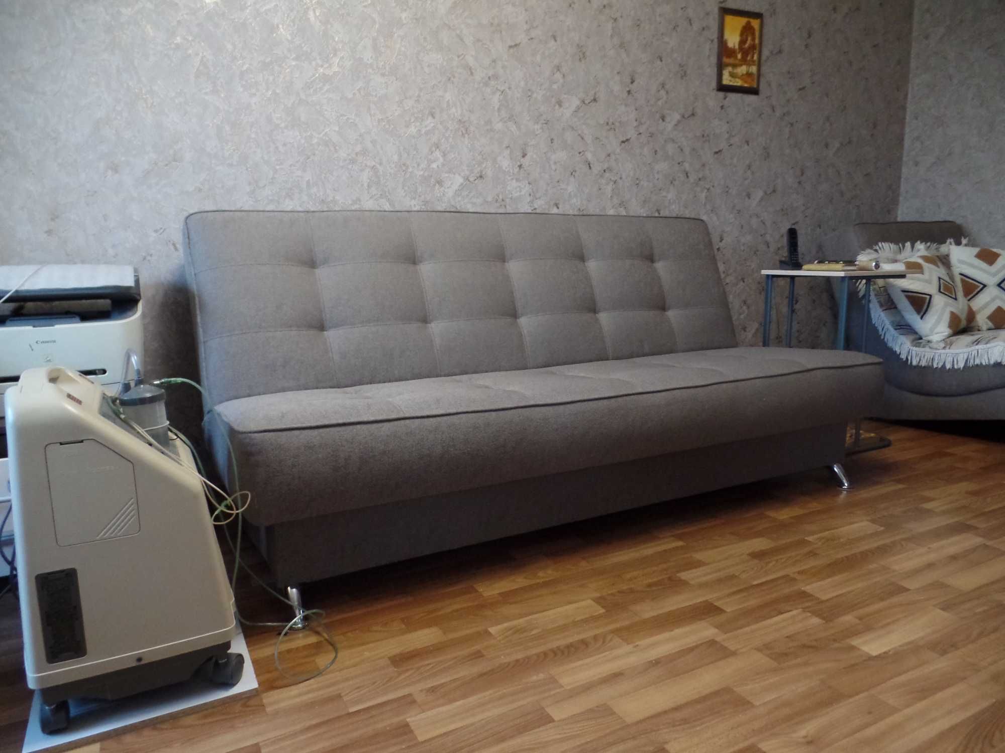 Диван серого цвета вместе с креслом.