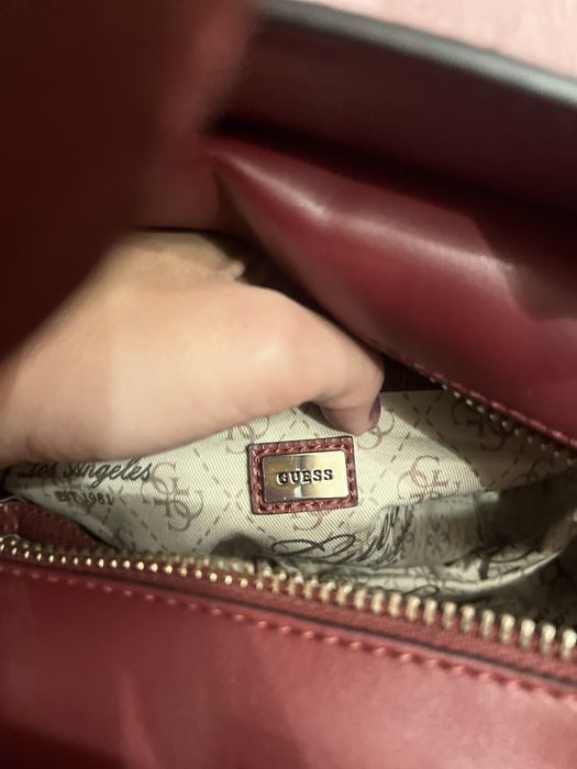 Geantă Guess bordo elegantă cu detalii aurii și textură snake