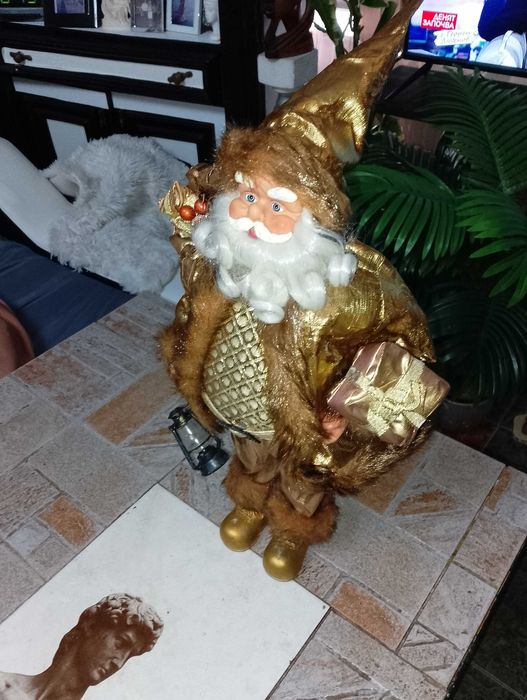 Дядо Коледа в златни одежди, касичка от кокосов орех