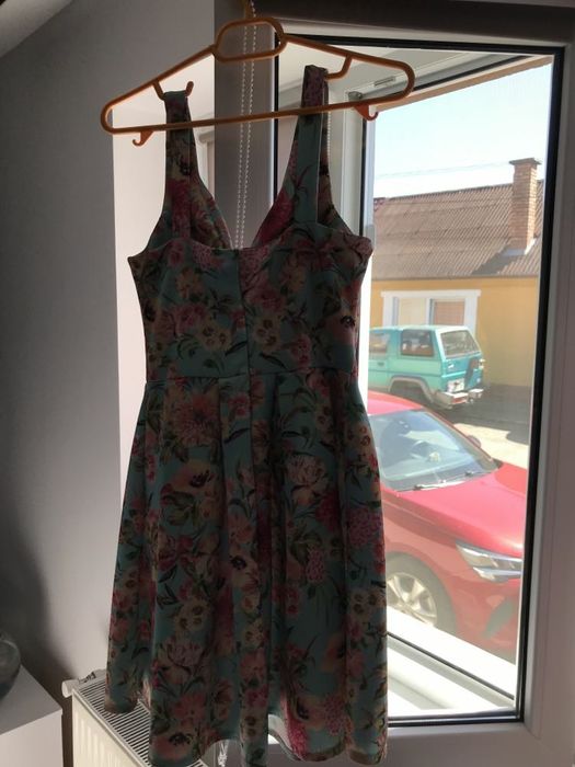Rochiță decoltată, elegantă de vară cu fundal turcoaz și flori.