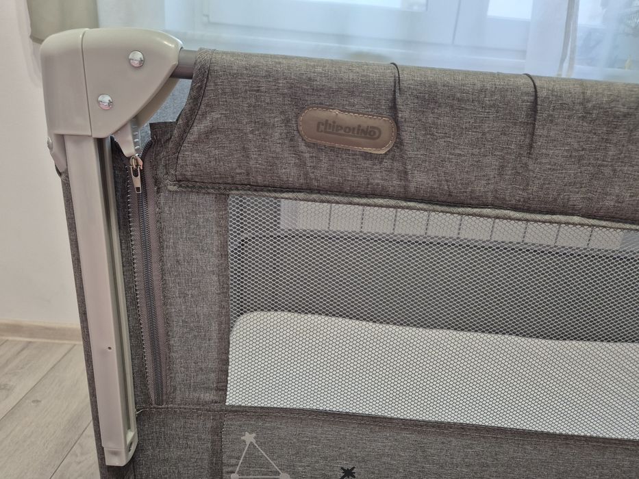 Pătuț pliabil Chipolino cu o laterală culisantă și saltea de cocos