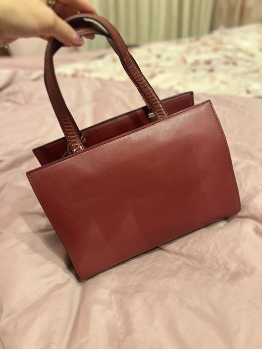 Geantă Guess bordo elegantă cu detalii aurii și textură snake