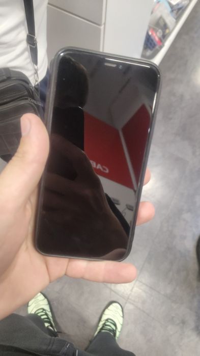 iPhone 11 ținut în folie