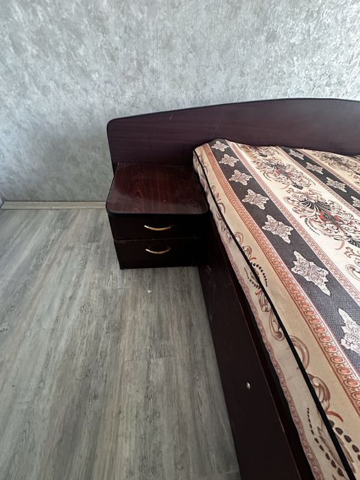 Кровать двуспальная имеет две прикроватные тумбочки