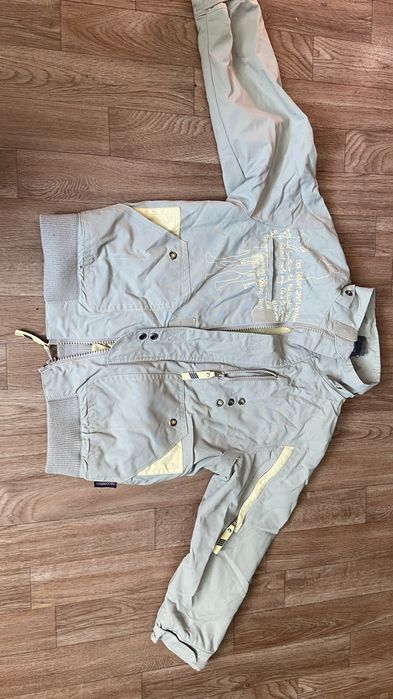 Ветровка светлого цвета.