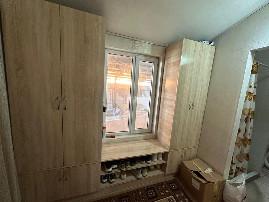 Деревянный шкаф между окном