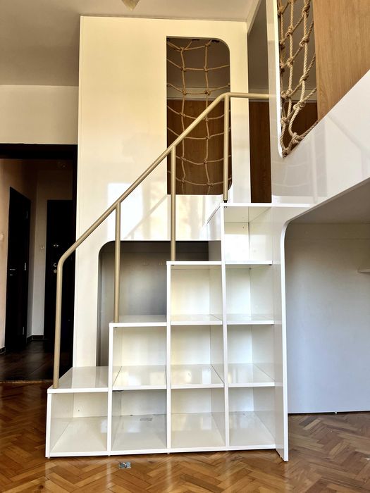 Детски легла на втори етаж със стълба, етажерки и ракли под тях