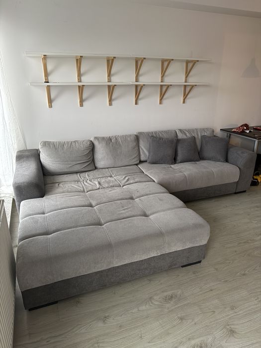 Canapea gri Mobexpert cu spatiu de depozitare si perne mici incluse