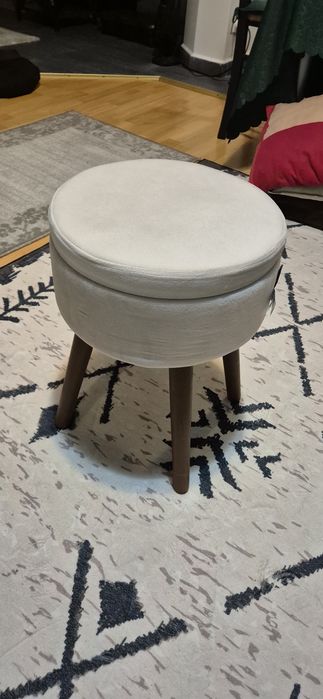 Otoman de depozitare, cu un design modern și picioare conice din lemn.