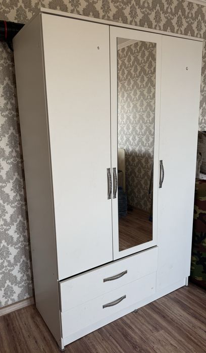 Белый трёхдверный шкаф с зеркалом и двумя выдвижными ящиками внизу.