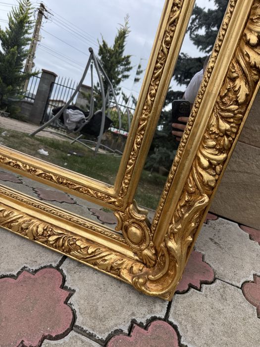 Oglinda impunatoare in stil baroc, cu rama aurie