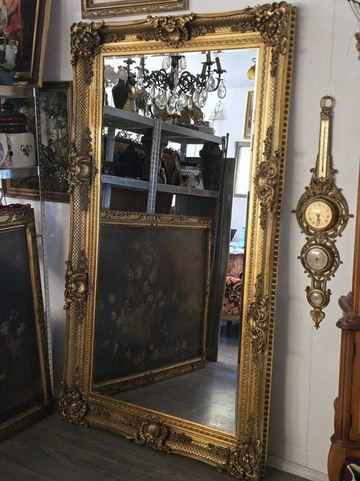 Imensa oglinda fazetata cu rama baroc.