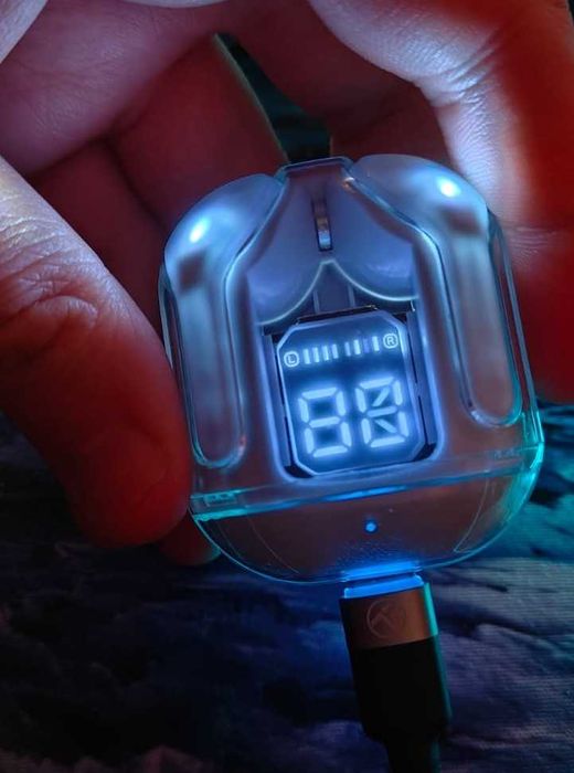 Căști TWS wireless, model cu carcasă transparentă și afișaj LED.