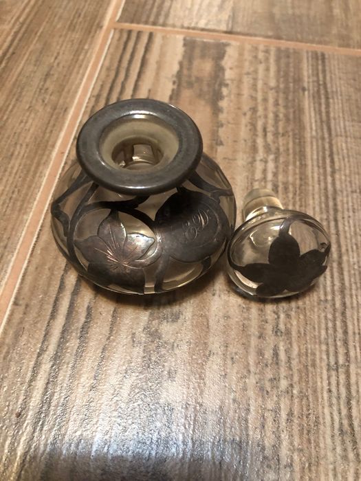 Малко шишенце облечено с нежна сребърна дантела