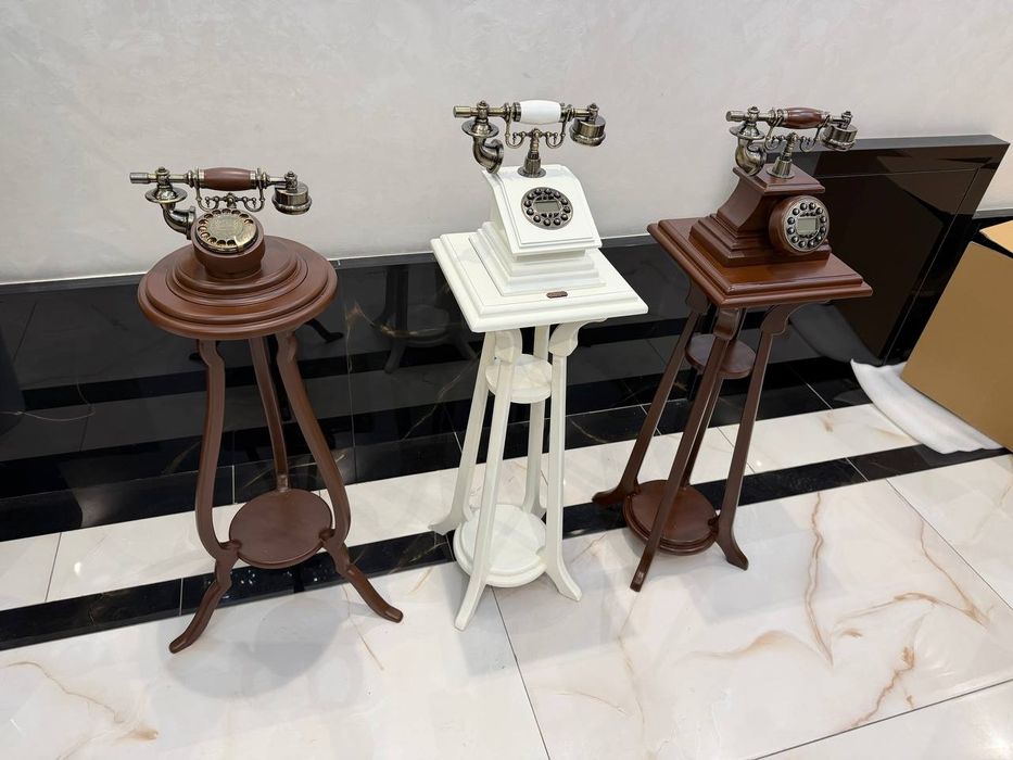 Антикварный декоративный телефон в стиле ретро, стоящий на деревянной