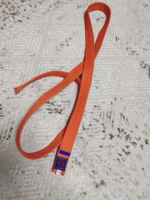 Продам оранжевый пояс с синей нашивкой