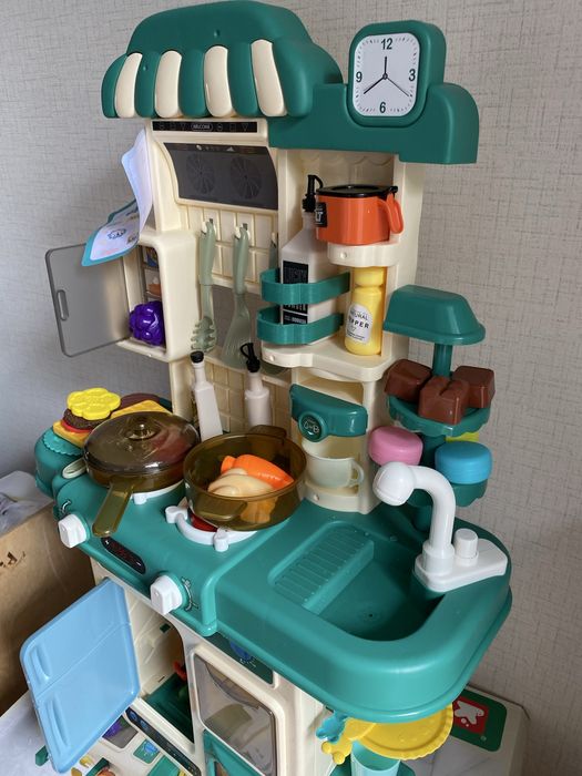 Кухня със светещи котлони, пара и мивка с течаща вода