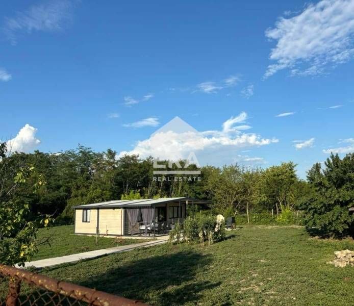 Обзаведена къща (тип сглобяема) с двор и голяма веранда за продажба в