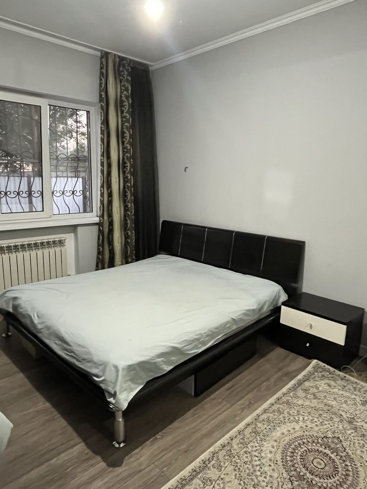 Кровать с две тумбочками, под кроватью еще есть два мини комод.