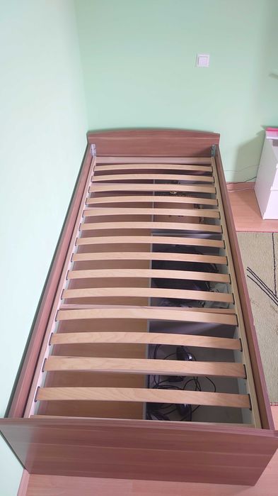 Pat o persoana cu somiera si sertare depozitare