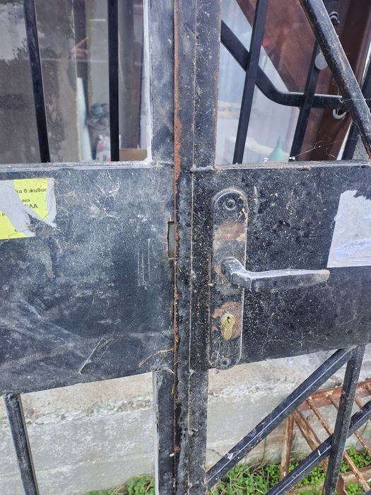 Голяма метална външна врата с две решетки. Много висока