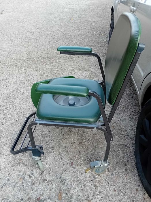 Scaun wc masiv pe roti verde.