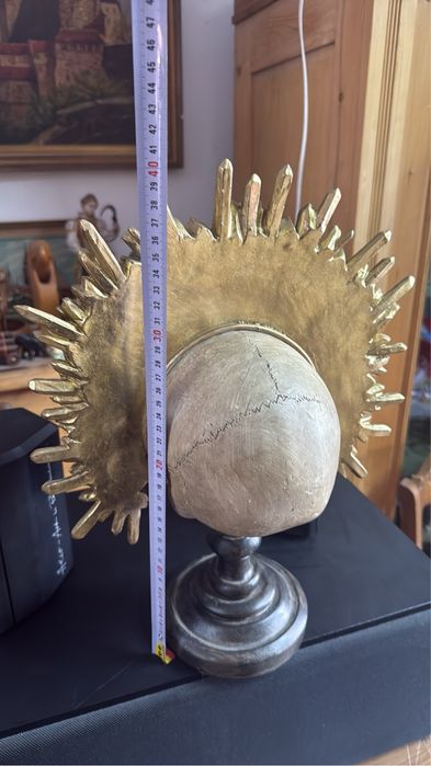 Craniu decorativ sculptata pe stativ cu coroană aurie detaliată