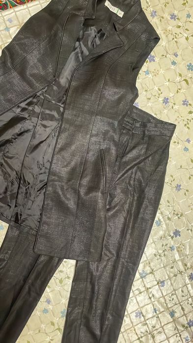 Чёрный женский костюм из блестящей ткани, безрукавки и брюк.