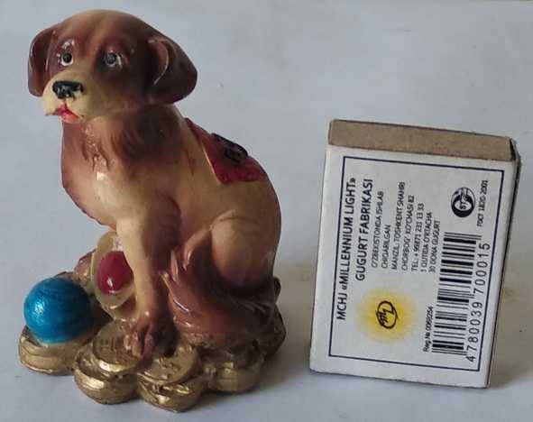 Керамическая собачка, сидящая на монетах