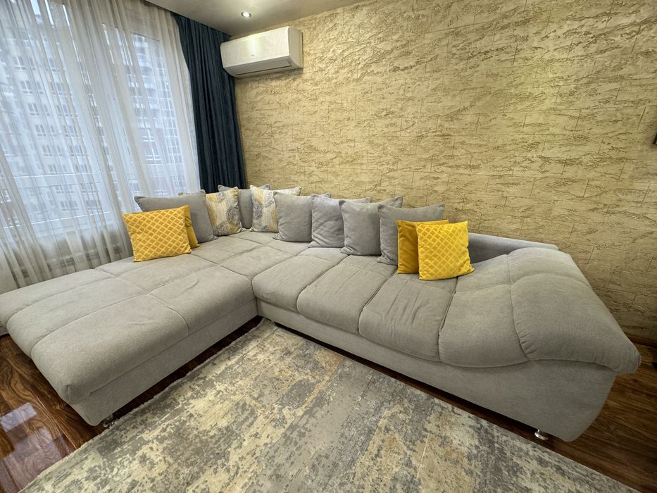 Сив ъглов диван с декоративни възглавници