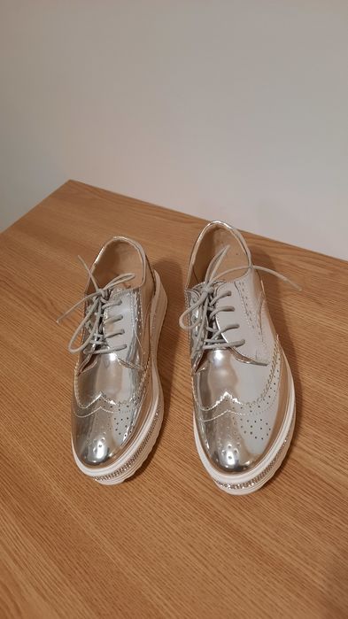 Vând pantofi NOI imitație de piele de culoare argintie.