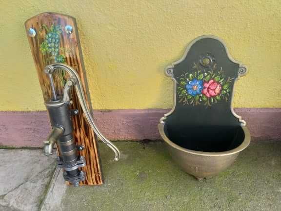 Fantana vintage din fonta asezata pe un suport de lemn