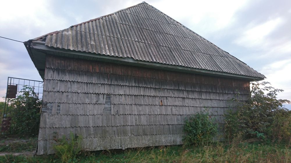Cabană pretabilă pentru mutat din bârne groase, îmbrăcată în draniță..
