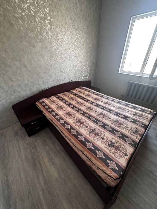 Кровать двуспальная имеет две прикроватные тумбочки