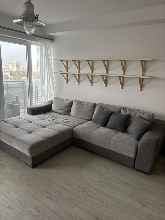 Canapea gri Mobexpert cu spatiu de depozitare si perne mici incluse