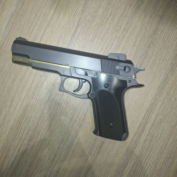 Игрушечный пистолет с пружинно спусковой конструкцией