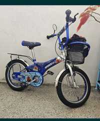 Детско велосипед с пимощни колела и кошница за багаж.