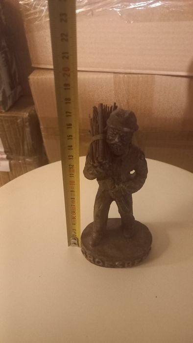 Статуетка на мъж с дърва на рамо