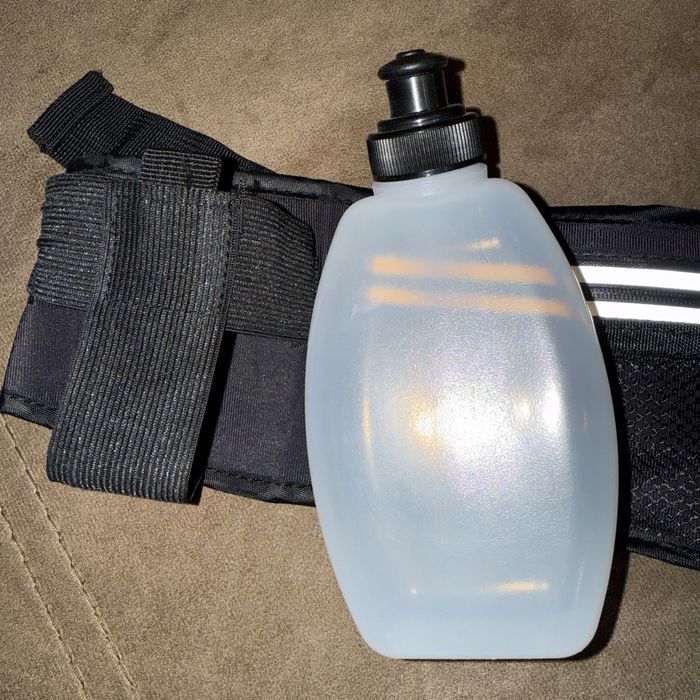 Спортен колан за бягане с две бутилки за вода.