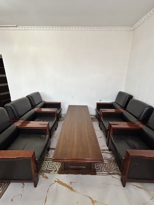 Это деревянный стол для совещаний с кожаными стульями.