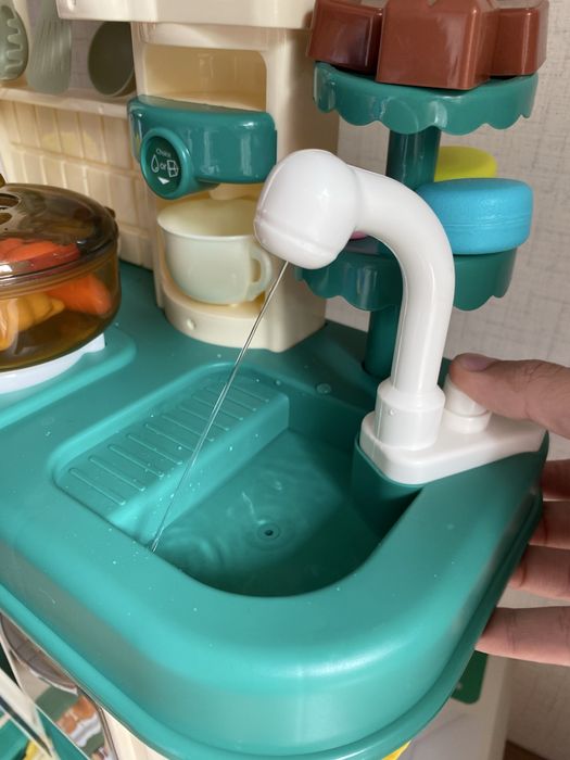 Кухня със светещи котлони, пара и мивка с течаща вода