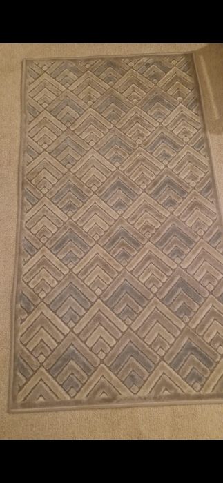 Covor cu motive  dungate si culori calde.