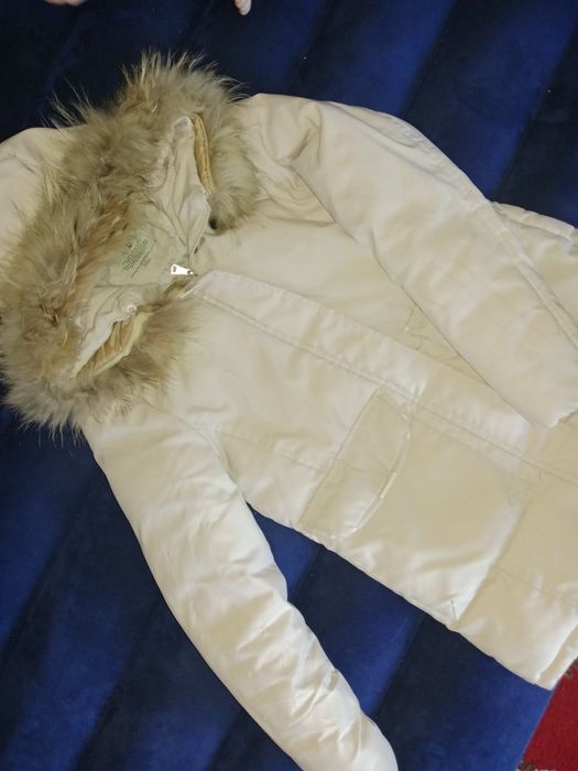 Куртка бежевого цвета.